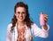 Smiling pediatrician woman bottle of drinking yogurt on blue