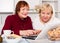 Smiling pensioners females with laptop