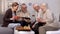 Smiling pensioners watching online video tablet together, playing chess, hobby