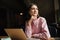 Smiling pensive woman sitting by the table in cafe