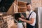 smiling pest control worker spraying pesticides on shelves