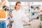 Smiling pharmacist help in choosing at counter