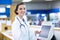 Smiling pharmacist holding medicine container in pharmacy