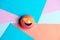 Smiling pink emoticon with heart eyes, on multicolored geometric texture