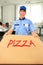 Smiling pizza delivery man holding pizza box