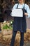 Smiling pleased Caucasian female floriculturist standing outside