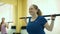 Smiling Plump Woman Doing Exercises with Barbell