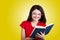 Smiling Portrait of a cute little schoolgirl loving to learn, holding with hands a book and wearing glasses