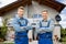 Smiling Portrait Of Two Male Handymen In Front Of House