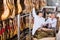 Smiling positive butchery technologists checking joints of iberico jamon