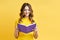 Smiling positive girl reading book on yellow background