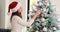 Smiling positive woman enjoying decorating Christmas tree