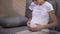 Smiling pregnant mother touching belly feeling baby kicks, emotions of happiness