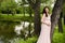 Smiling pregnant woman 25-29 year old resting by the lake. Posing outdoors. Motherhood. Maternity.