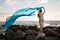 Smiling Pregnant Woman on the Beach with Blue Veil