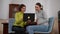Smiling pregnant woman and psychoanalyst using laptop talking sitting indoors. Portrait of positive confident Caucasian