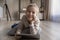 Smiling preteen girl lying on warm floor holding digital tablet