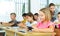 Smiling preteen girl using smartphone at lesson in school