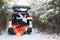 smiling pretty woman in car trunk at snowed winter forest