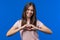 Smiling pretty woman showing sign of shape heart. Positive teenager on blue background. Women health, volunteering