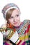 Smiling pretty young girl wearing coloful knitted scarf, hat and mittens, holding christmas gift isolated on white background.