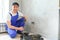 Smiling professional electrician in uniform replacing a socket in apartment after renovation work