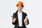 Smiling professional female architect, asian engineer in helmet and business suit, holding blueprints and pen, siging