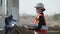 Smiling professional female heavy industry engineer in a helmet background of a construction site in hangar where