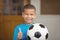 Smiling pupil holding football and doing thumbs up