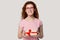 Smiling red-haired girl make present holding gift box