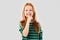 Smiling red haired girl making shush gesture