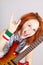 Smiling red-haired Italian girl with guitar