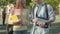 Smiling redhead woman talking with unrecognizable man in university yard. Portrait of positive Caucasian students