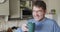 Smiling and relaxed caucasian man drinking coffee in kitchen at home