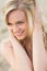 Smiling relaxed young blond looking away at beach