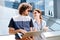 Smiling remote worker drinking coffee standing near her freelance boyfriend