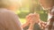 Smiling retired couple relaxing in park, holding hands and talking about love