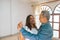 Smiling retired spouses enjoying a weekend in the living room