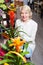 Smiling retiree female customer choosing flowers