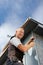 Smiling roofer assembles a metal piece on a wall