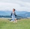 Smiling running beagle dog portrait with tongue out and happy owner female jogging by the mounting meadow grass path. Walking in