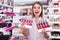 smiling salesgirl suggesting various nail polishes at store