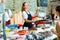 Smiling saleswoman offering fresh shrimps to woman in seafood shop