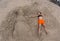 Smiling sandy snowman in red santa hat on the sea