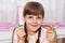 Smiling satisfied female kid looking directly at camera, having many colored crayons and pencils, holds in hands multicolored felt