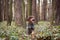 Smiling and satisfied female Rough-coated Bohemian Pointer sitting in the middle of forest in bushes and watching what is