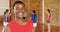 Smiling school boy holding a basketball while team playing in background