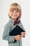 Smiling School boy in shirt with red bow tie, holding tablet computer in white background