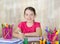 Smiling school girl draws at desk