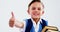 Smiling schoolboy with books showing thumbs up